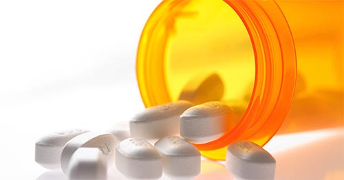 Pills spilling out of a bottle.