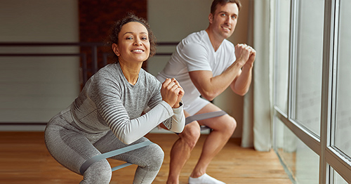 A couple doing squat exercises.
