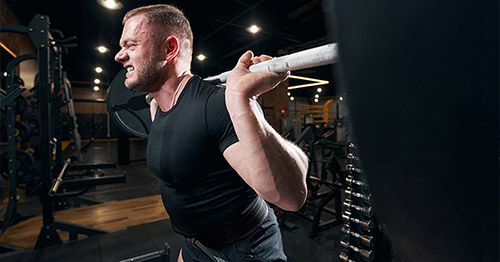 A male weightlifter grimacing.