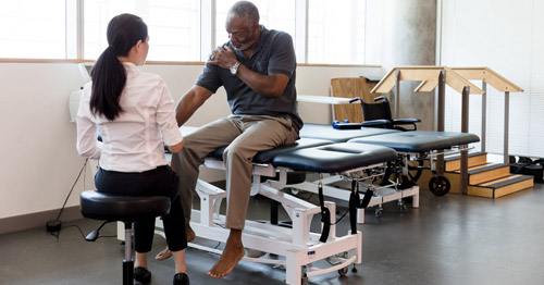 Middle aged man getting occupational therapy for upper extremity.