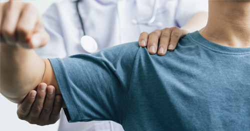 A man getting a physical exam of the shoulder.