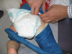 Tucking small diaper inside back.