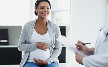 A pregnant woman with a clinician.