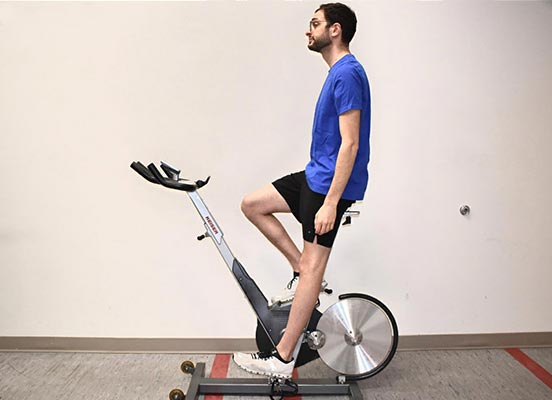 man on exercise bike demonstrating seat height position