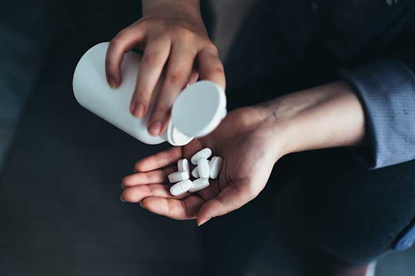 A hand pouring pills.
